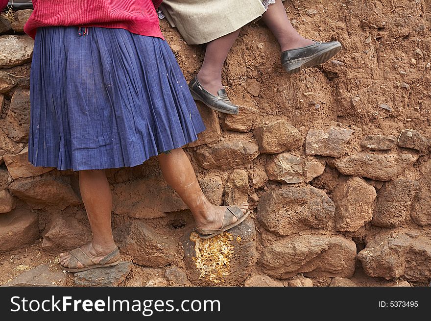 Two Andean women sitting on a wall near Cusco, Peru. Two Andean women sitting on a wall near Cusco, Peru.