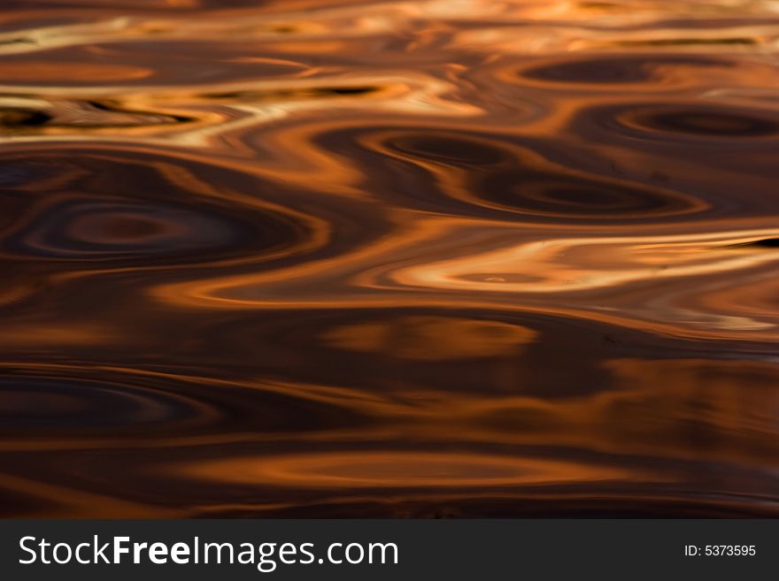 Colorful reflections on a water surface. Reflection of the sky at a sunset.