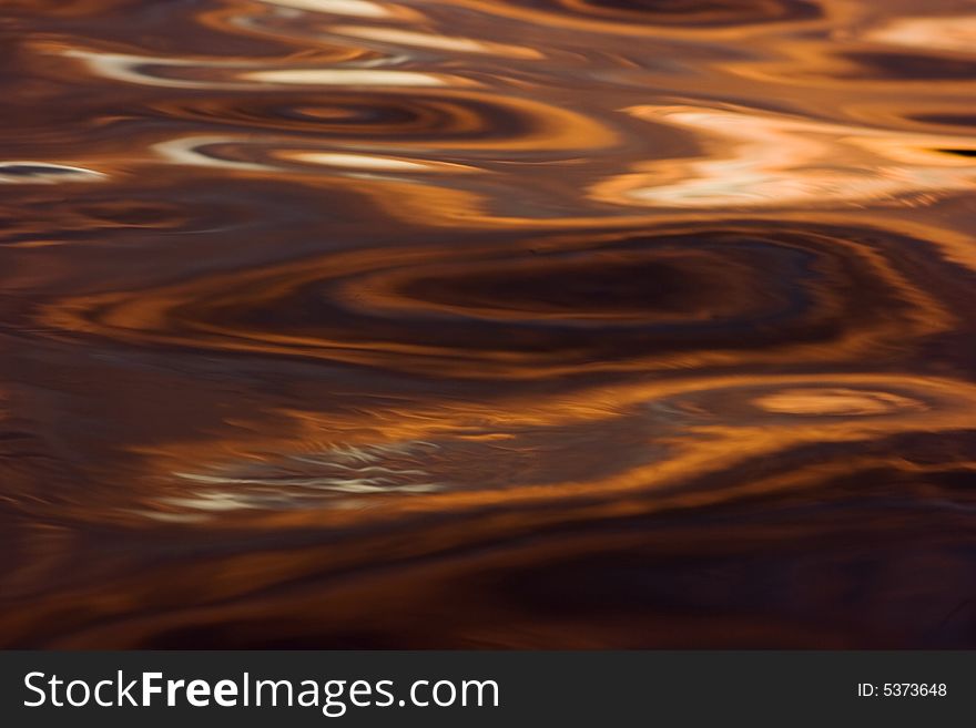 Colorful reflections on a water surface. Reflection of the sky at a sunset.