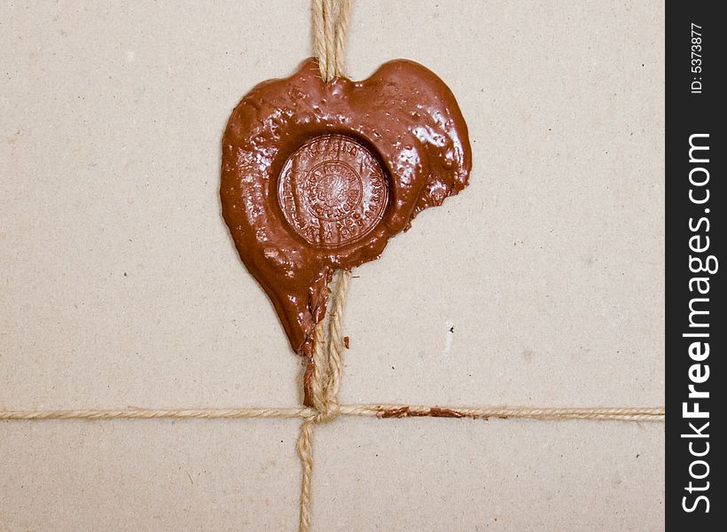 Closeup of cardboard parcel tied up and sealed with sealing wax. Closeup of cardboard parcel tied up and sealed with sealing wax