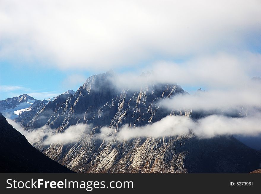 When travelling in Tibet of China, a grand mountain in clouds appears in front of us. When travelling in Tibet of China, a grand mountain in clouds appears in front of us.