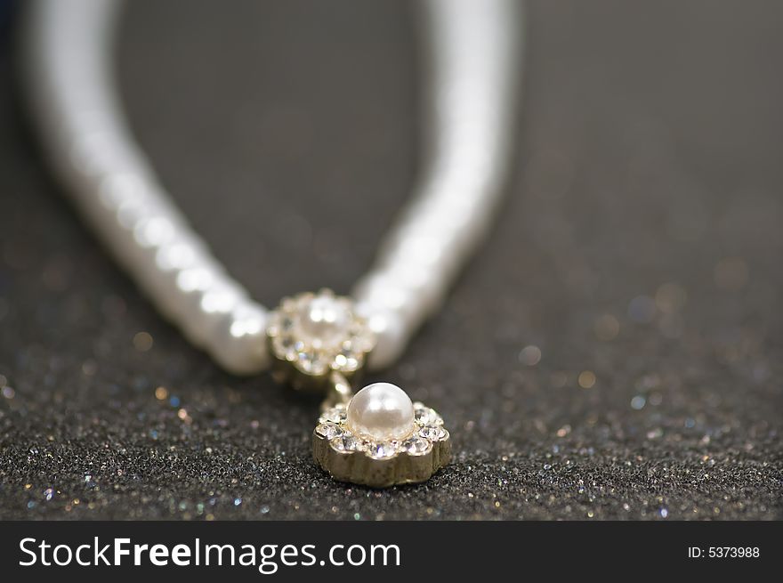 Close up on old pearl necklace on gray glittering background