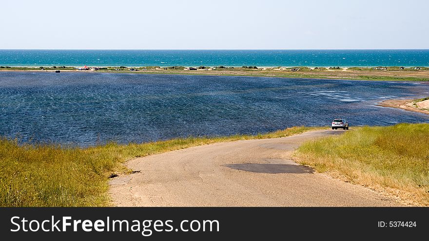 Corkscrew road to the sea with a car on it