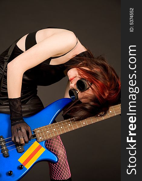 Crazy musician with bass guitar on black background