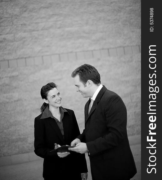 Businessman and businesswoman standing working together discussing. Businessman and businesswoman standing working together discussing