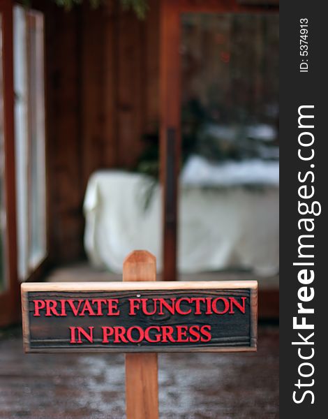 Wooden sign with red text letters warning of private function in progress. Wooden sign with red text letters warning of private function in progress