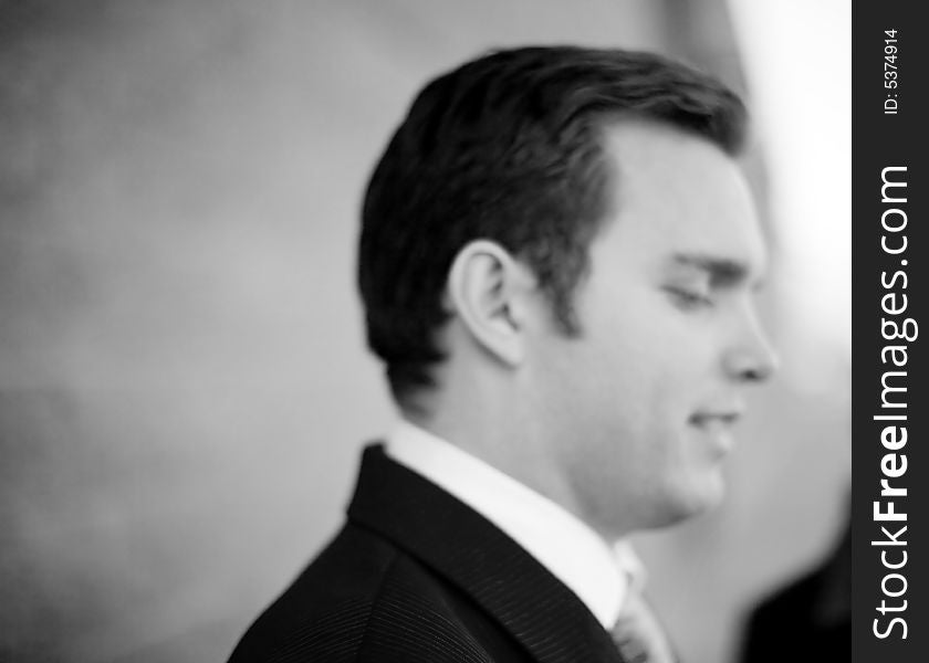 Close up of single white businessman in suit and tie standing looking down