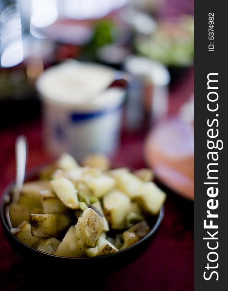 Bowl of cooked potatoes on table with other objects. Bowl of cooked potatoes on table with other objects