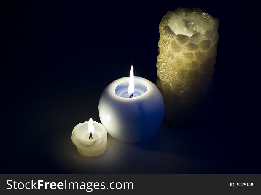 Three burning candles on a black background. Three burning candles on a black background