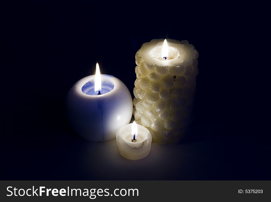 Three burning candles on a black background. Three burning candles on a black background
