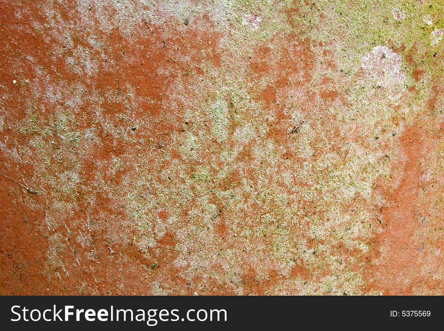 A terracotta plant pot showing signs of age with moss and mold. A terracotta plant pot showing signs of age with moss and mold