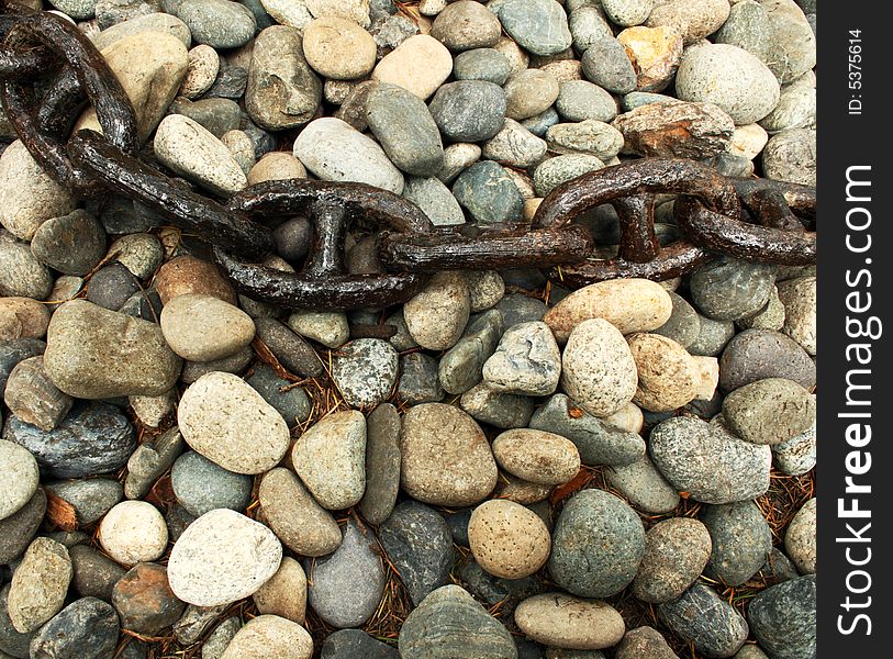 Close up on an old and rusty chain over a stone surface