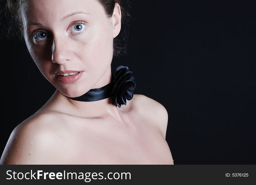 Portrait of the beautiful naked girl with an ornament on a neck on a black background. Portrait of the beautiful naked girl with an ornament on a neck on a black background