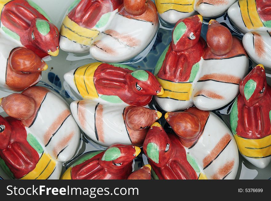 Colorful Ceramic ducks floating on the water.