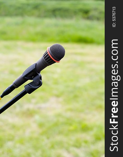 Microphone On Air Over Green Grass Background