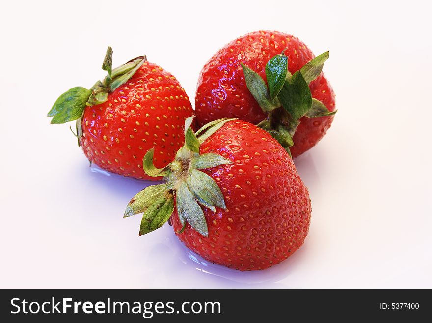 Close-up of three nice fresh strawberry lying in white background
