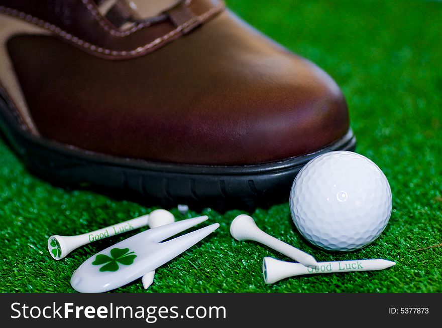 Golf-ball with tees shues on a green ground. Golf-ball with tees shues on a green ground