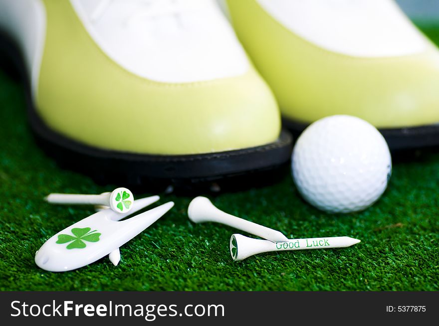 Golf-ball with tees shues on a green ground. Golf-ball with tees shues on a green ground