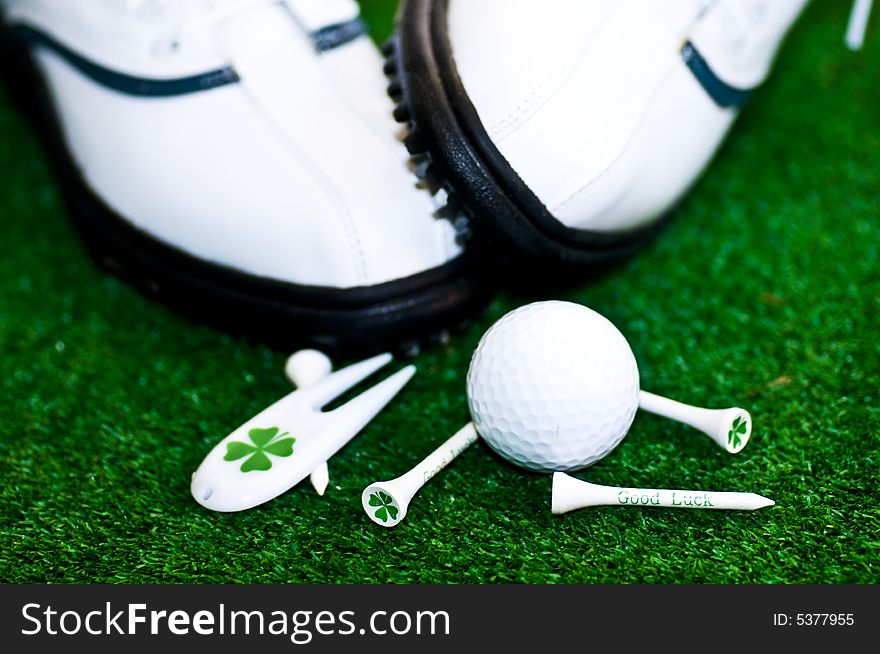 Golf-ball with tees shues on a green ground. Golf-ball with tees shues on a green ground