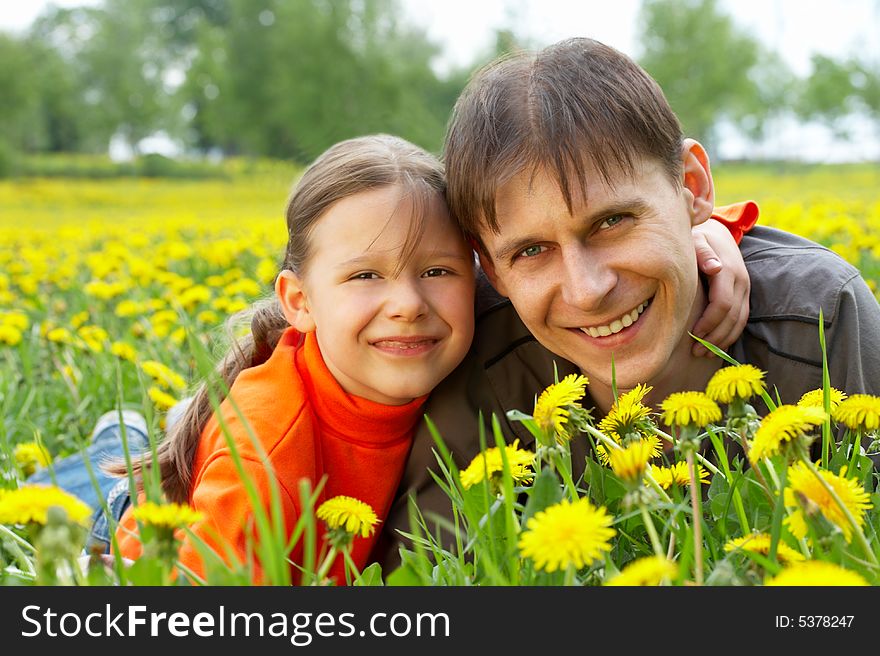 The small daughter and the father in embraces lay on a lawn. The small daughter and the father in embraces lay on a lawn