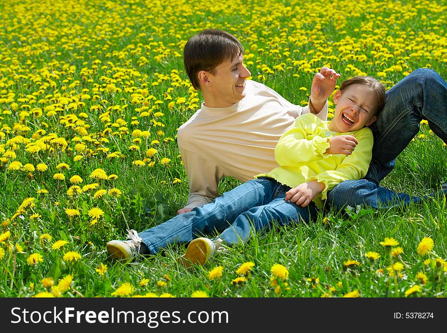 Father with daughter sit on a lawn and laugh. Father with daughter sit on a lawn and laugh