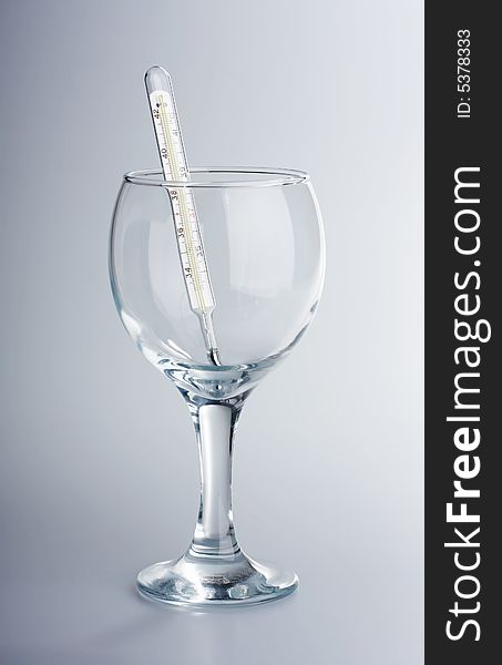 The thermometer in a glass glass on a white background. The thermometer in a glass glass on a white background