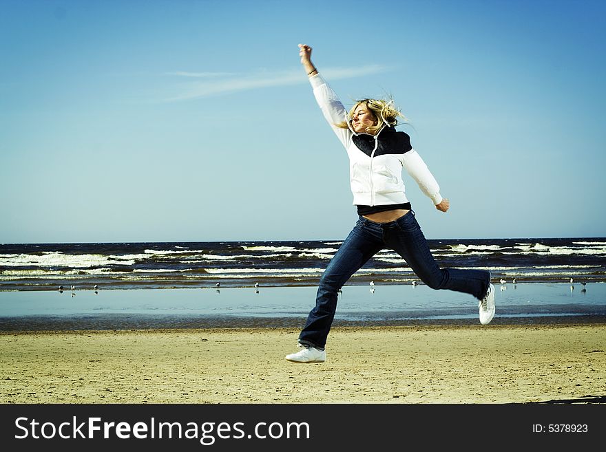 Young girl jumping on the beach. Young girl jumping on the beach.