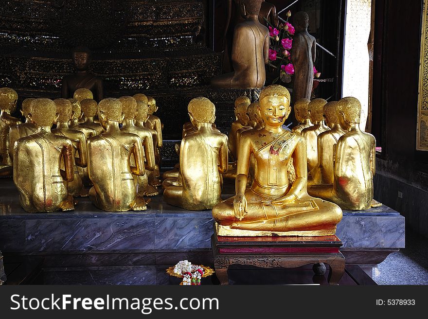 Thailand, in Bangkok the Wat Rachanada is situated in the old royal city; the ancient walls are decorated with murals depicting paradise and hell. View of the golden seated Buddha. Thailand, in Bangkok the Wat Rachanada is situated in the old royal city; the ancient walls are decorated with murals depicting paradise and hell. View of the golden seated Buddha