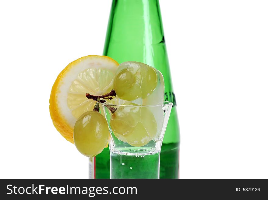 Close up to frozen grapes infront of a soda bottle