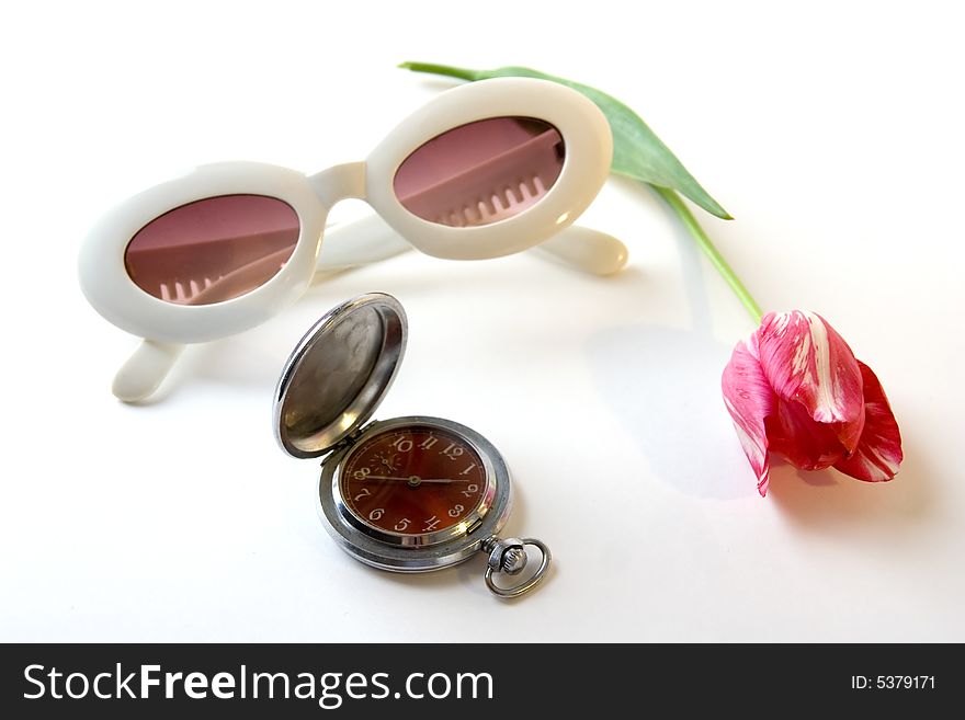 A photo of white sunglasses, metal watch and red tulip. A photo of white sunglasses, metal watch and red tulip