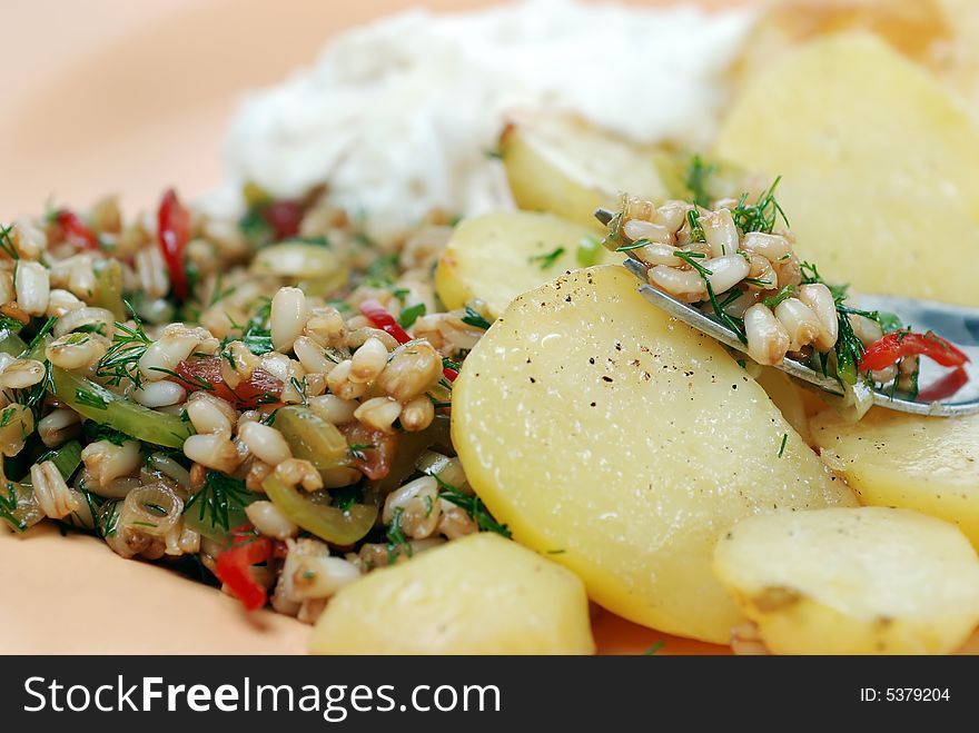 Delicious wheat salad with many ingredients served with oven baked potato. Delicious wheat salad with many ingredients served with oven baked potato