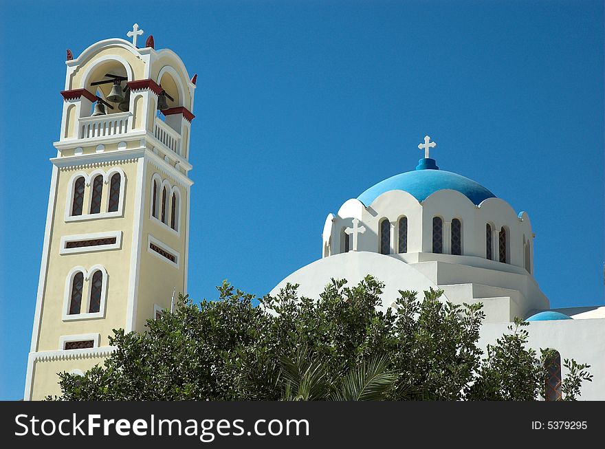 Bell tower and church in hot and sticky Santorini