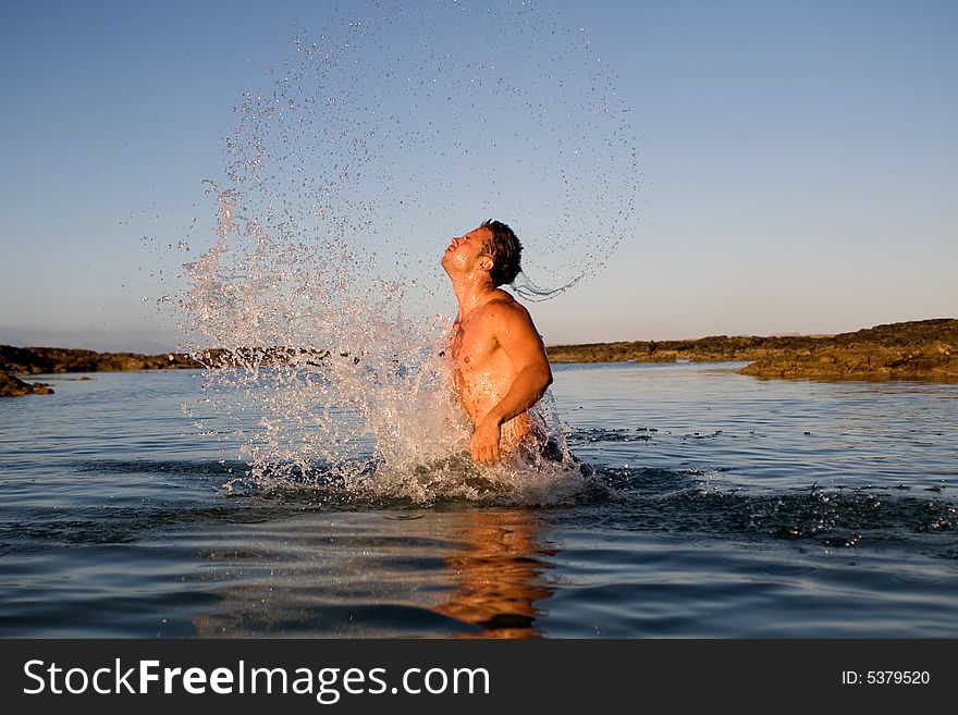 Young athetlic man jumping in the sea water. Young athetlic man jumping in the sea water