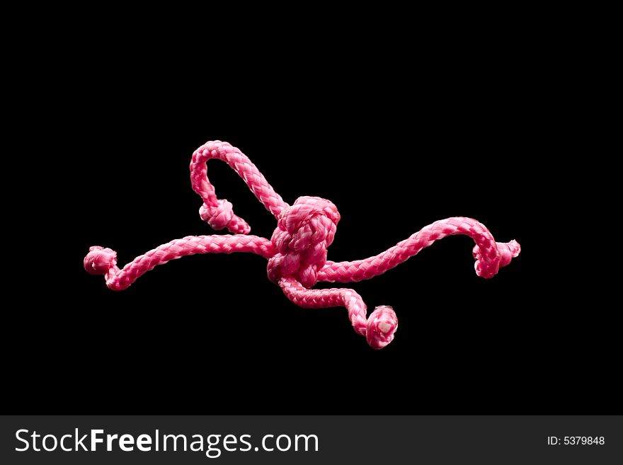 Pink ropes tied together by several Chinese knots, black background. Pink ropes tied together by several Chinese knots, black background