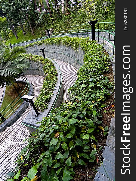A curve pathway with plants and railing