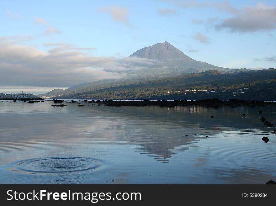 Pico mountain reflected upon the calm waters of Lajes do Pico, photo taken at dawn as the sun was rising. Pico mountain reflected upon the calm waters of Lajes do Pico, photo taken at dawn as the sun was rising