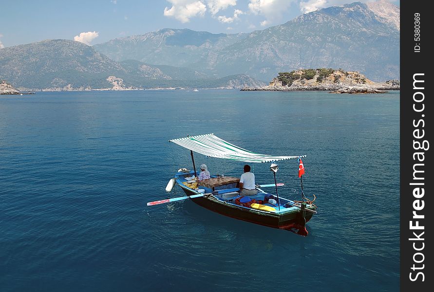 A man and a woman rowing on a small fishing boat