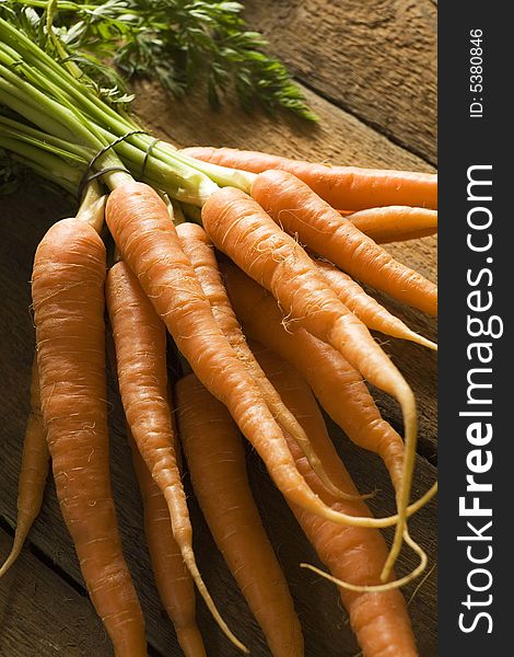 Bunch of carrots against wooden background