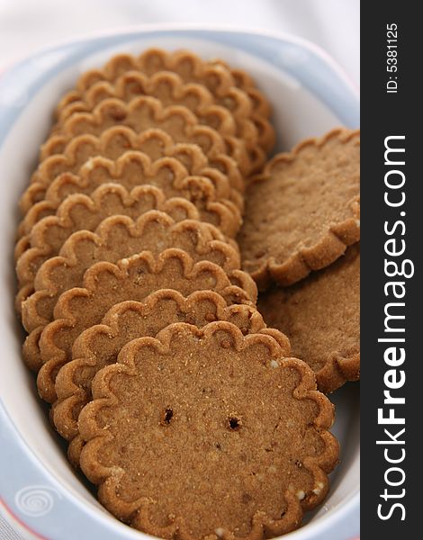 Small and brown cookies on the white plate. Small and brown cookies on the white plate