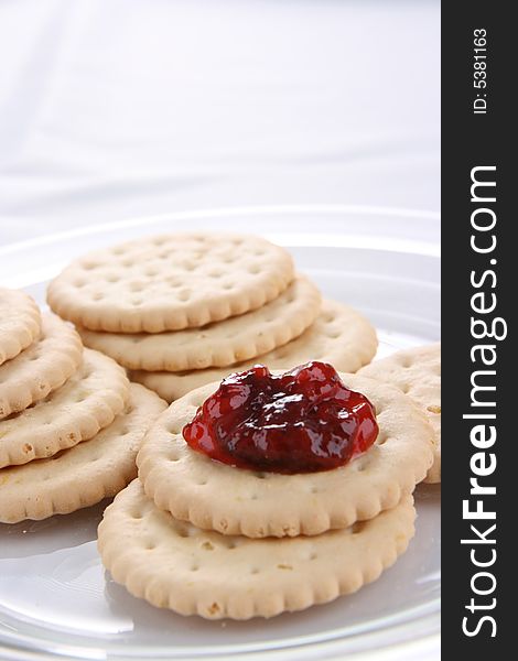 Round cakes with  fruity jam on the plate isolated on white. Round cakes with  fruity jam on the plate isolated on white