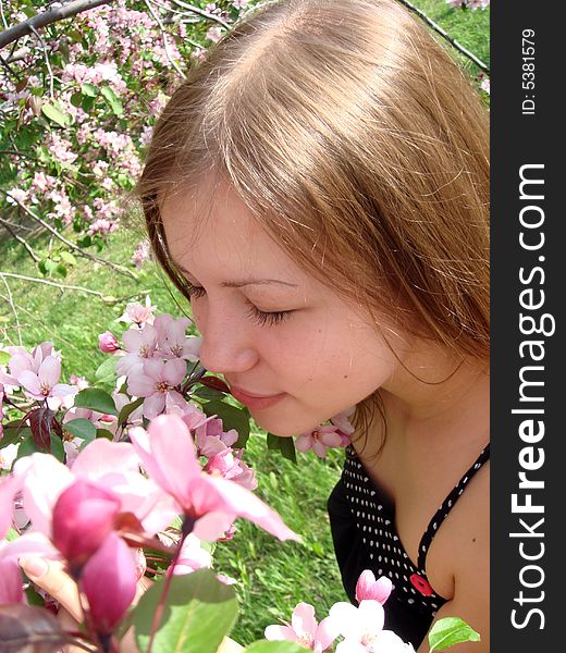 Beautiful young girl at the apple tree. Spring nature.