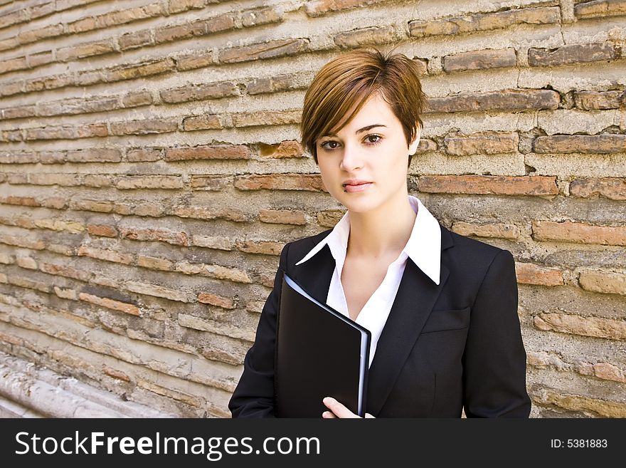 Smiling businesswoman posing on the wall. Smiling businesswoman posing on the wall