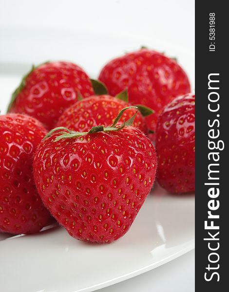A bunch of strawberries on a plate over white background