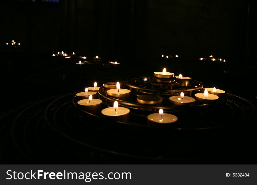Candles burning in darkness inside a church. Candles burning in darkness inside a church