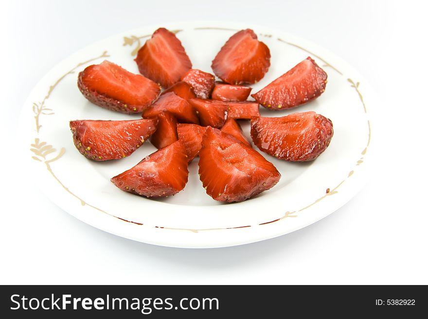 Sliced strawberries on plate over white