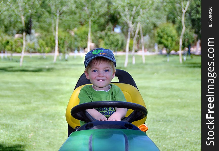 Young child on riding mower exited to help out. Young child on riding mower exited to help out