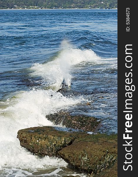 Water crashing against a rocky shoreline. Water crashing against a rocky shoreline