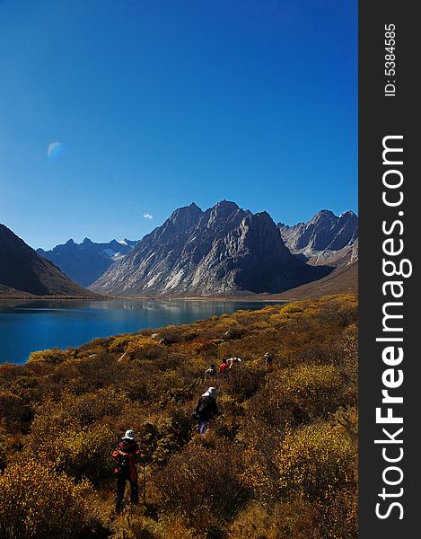 When travelling in Tibet of China, we see a beautiful lake and mountain in front us, when some brave travellers walking around it though the boskage. When travelling in Tibet of China, we see a beautiful lake and mountain in front us, when some brave travellers walking around it though the boskage.