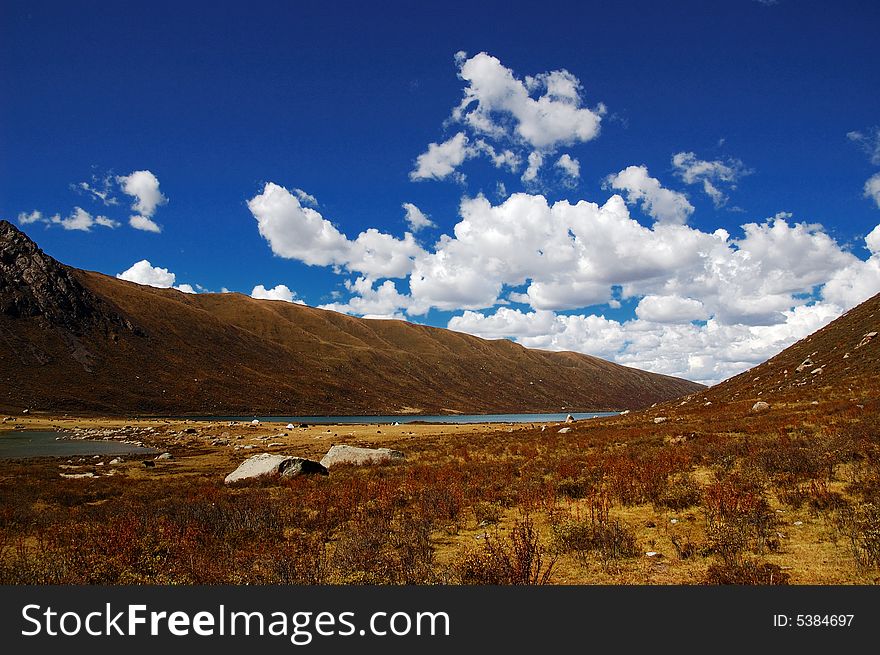 When travelling in Tibet of China,  meadows appear in front of us, and a lake on it is not far away from us. When travelling in Tibet of China,  meadows appear in front of us, and a lake on it is not far away from us.