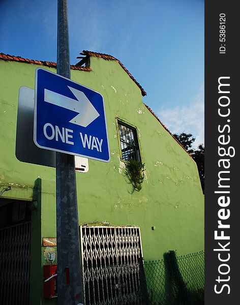 Picture of sign showing there's only one way. Against the background of the old building, the picture suggests that the only way is to improve and not get left behind (like the old building).